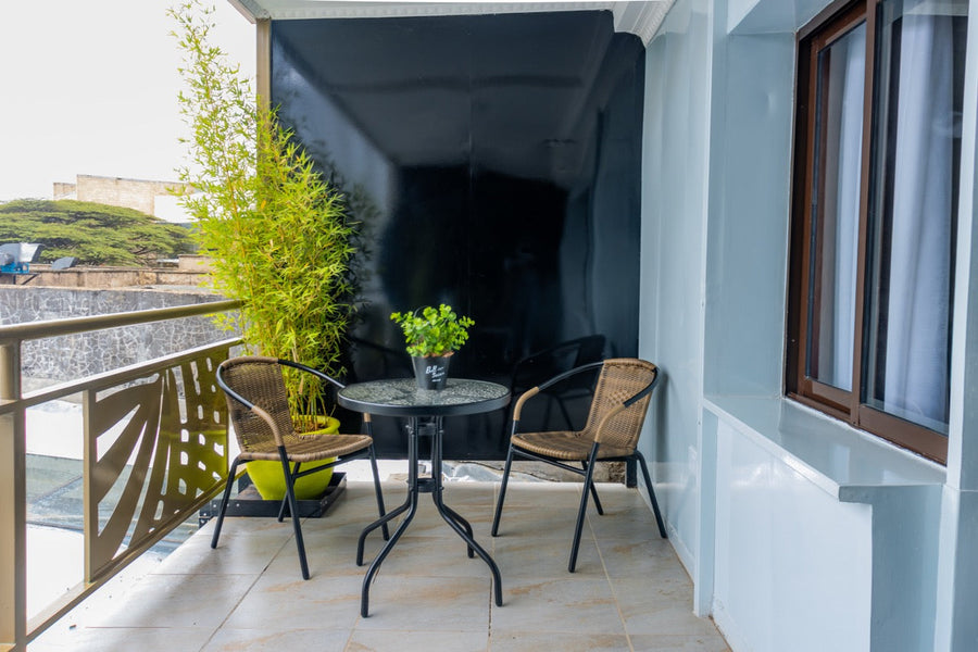 Balcony at Karen Plains Hotel overlooking green trees in Karen, Nairobi, a base for photographing jacarandas