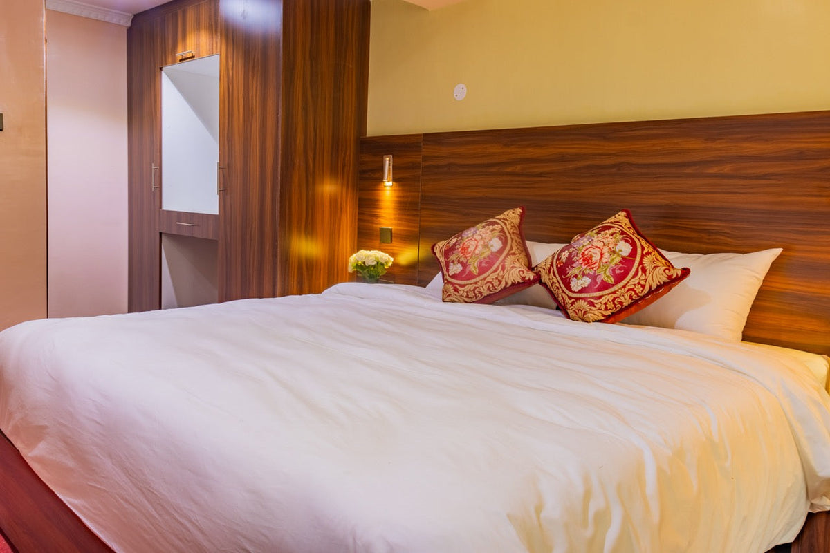 Guest room with red and gold cushions at Karen Plains Hotel, a comfortable bed for one night in Karen, Nairobi
