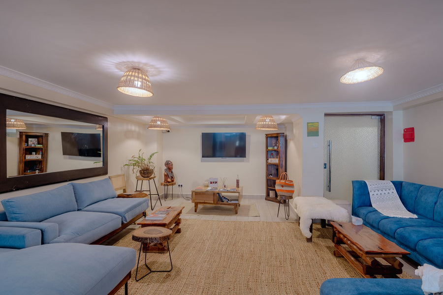 Shared lounge with blue sofas at Karen Plains Hotel, a gathering space for group travellers in Karen, Nairobi